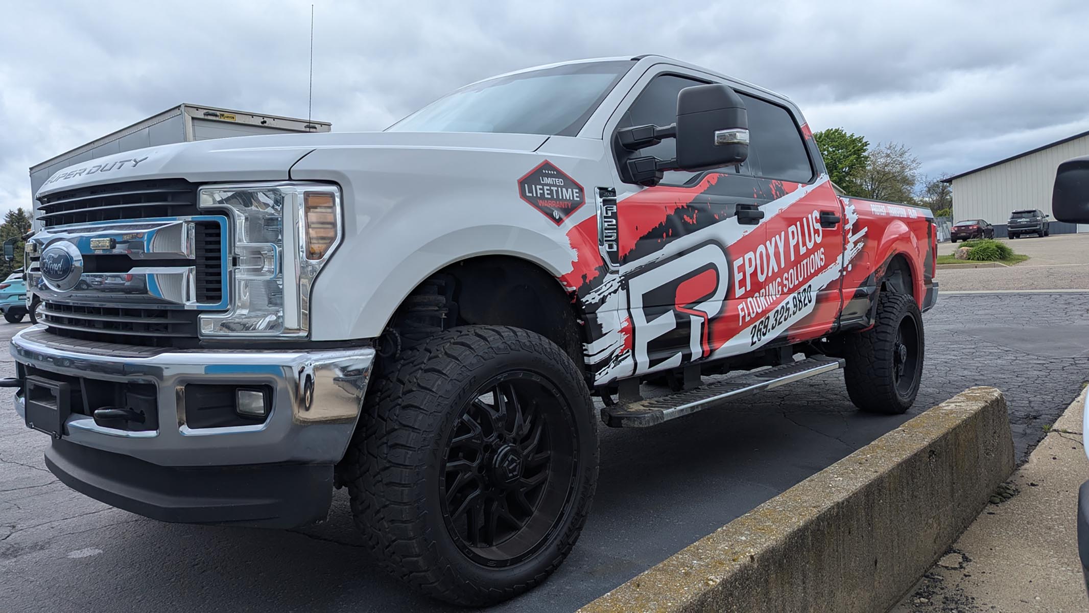 Epoxy Plus Flooring Solutions red, black and white partial wrap on Ford F250.