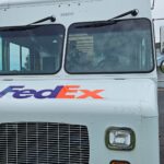 fedex truck front near wraps n signs building